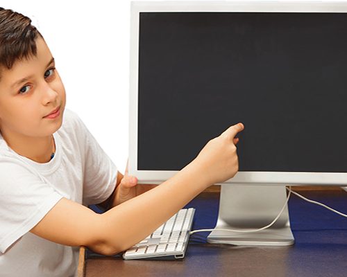 School-age boy sitting with the monitor laptop at studio School-age boy sitting with the monitor laptop at studio